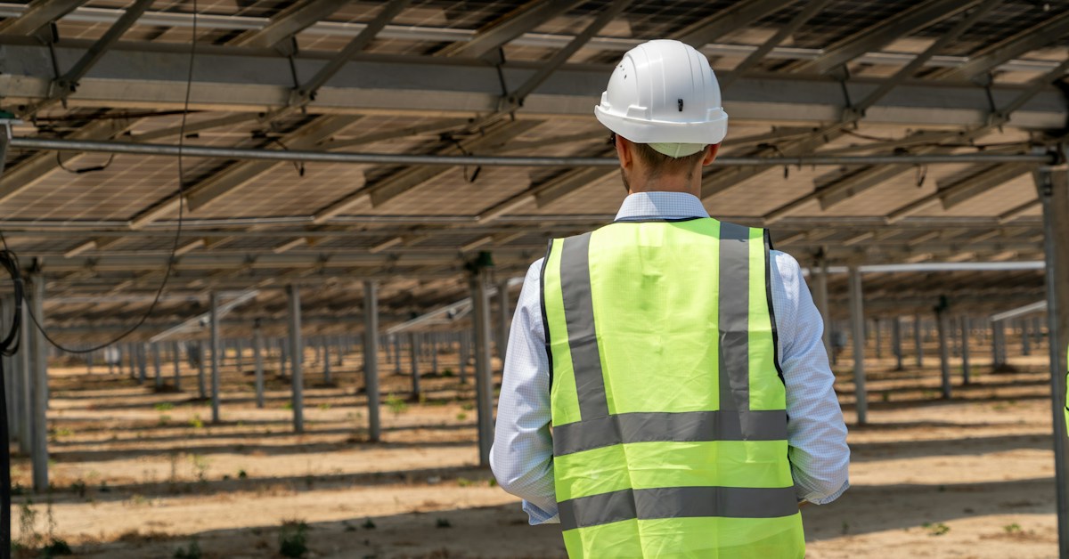 Solar engineer inspecting photovoltaic modules for performance and product warranty evaluation